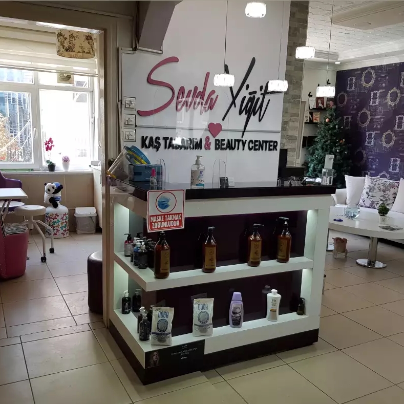 Sevda Yiğit Kaş Tasarım & Güzellik Merkezi salon içi — karşılama bankosu ve logo